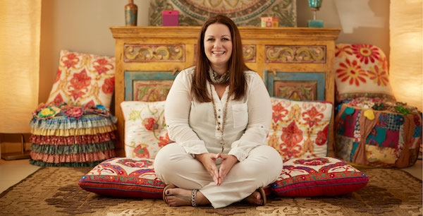 woman sitting in meditation pose in comfortable room