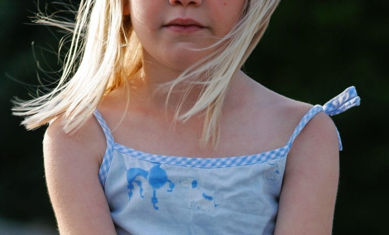 close up of young girl sitting outside