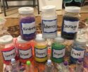 bottles of paint with positive nouns on labels such as "kindness", "courage"